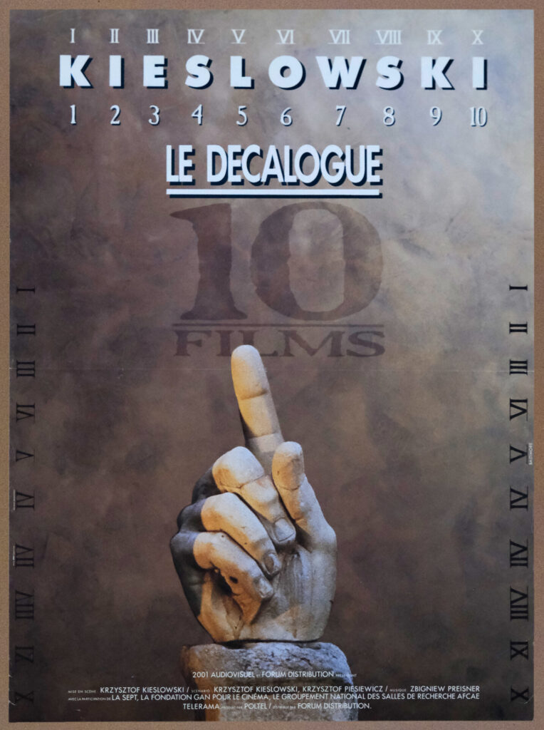 Francuski plakat do cyklu filmowego „Dekalog". Rzeźbiona dłoń wskazuje palcem w górę.