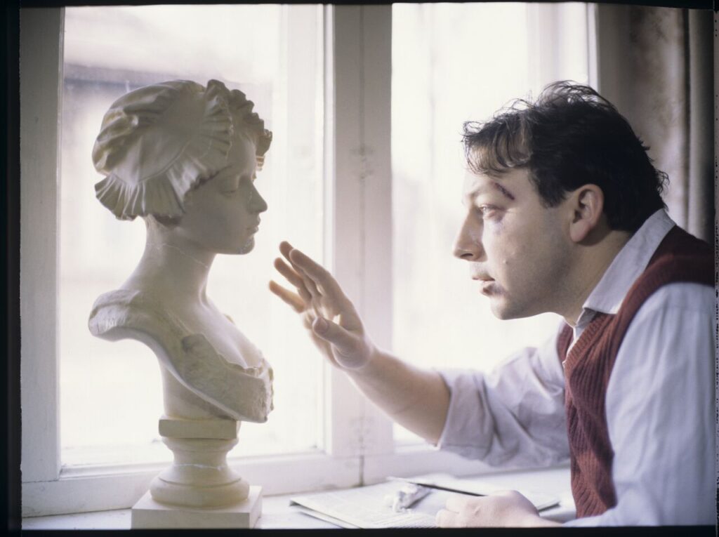 Karol ustawia na parapecie okna w swoim nowym biurze przywiezione z Francji gipsowe popiersie kobiety.