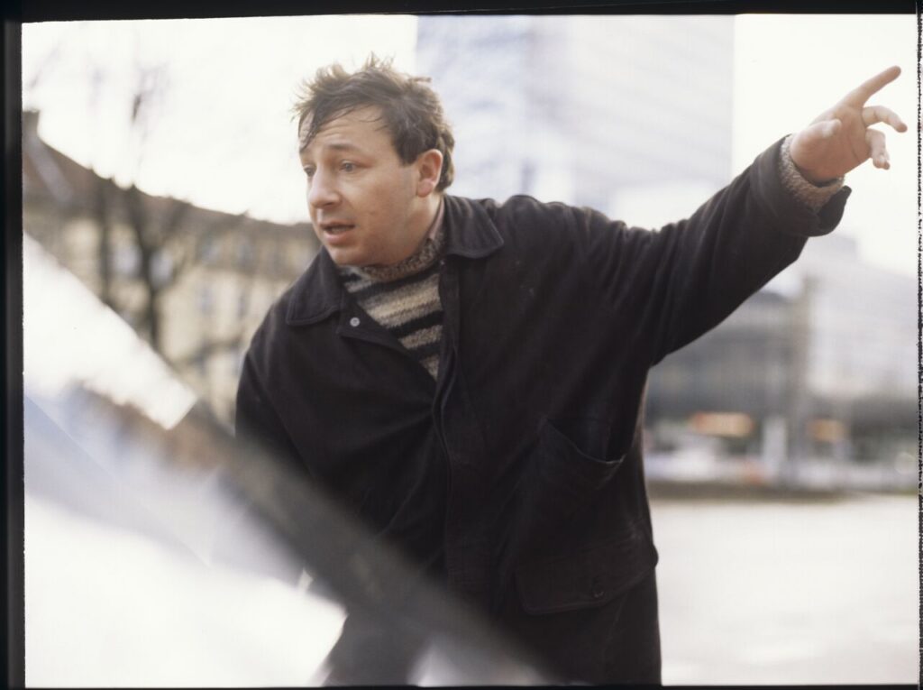 Karol (Zbigniew Zamachowski) stops a car with "Blondynka" driving down the street.