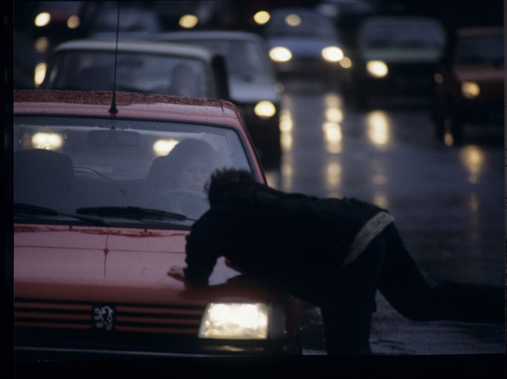 Karol (Zbigniew Zamachowski) stops a car with "Blondynka" (Grażyna Szapołowska) driving down the street.