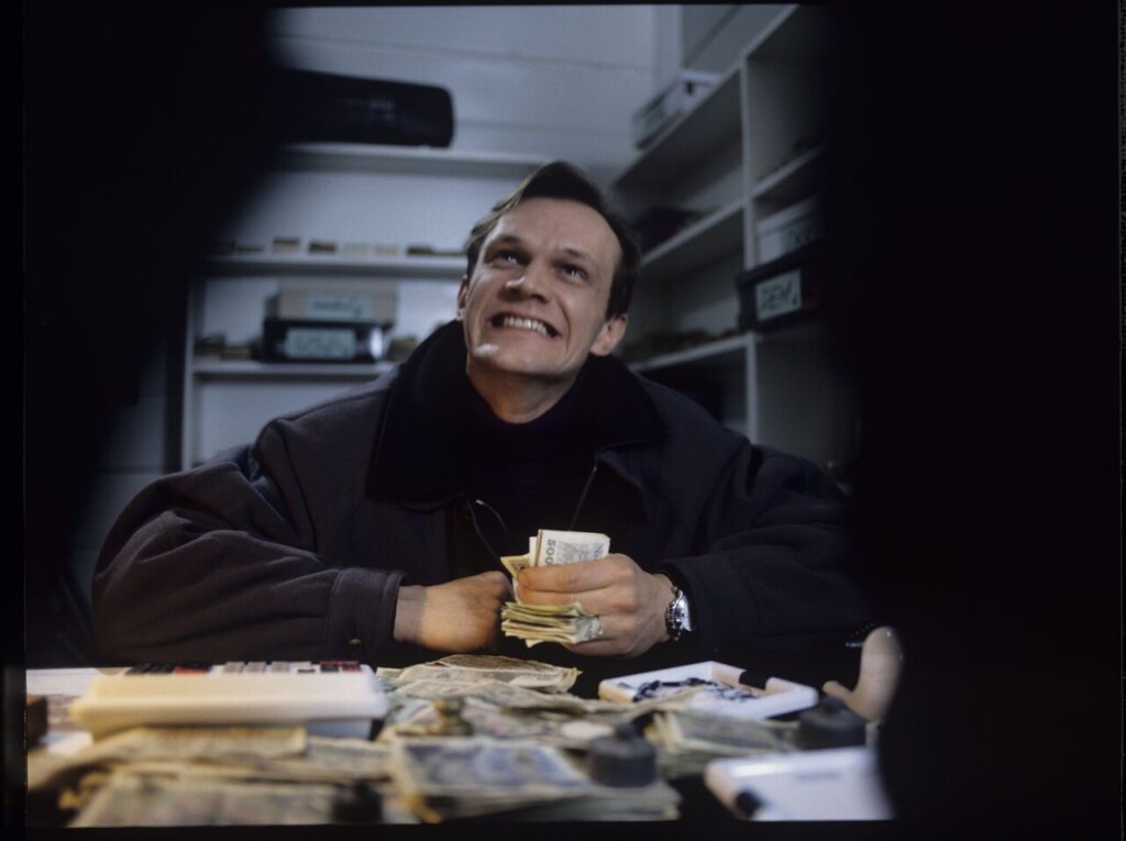 The owner of currency exchange bureau (Cezary Pazura) in the scne of counting the money