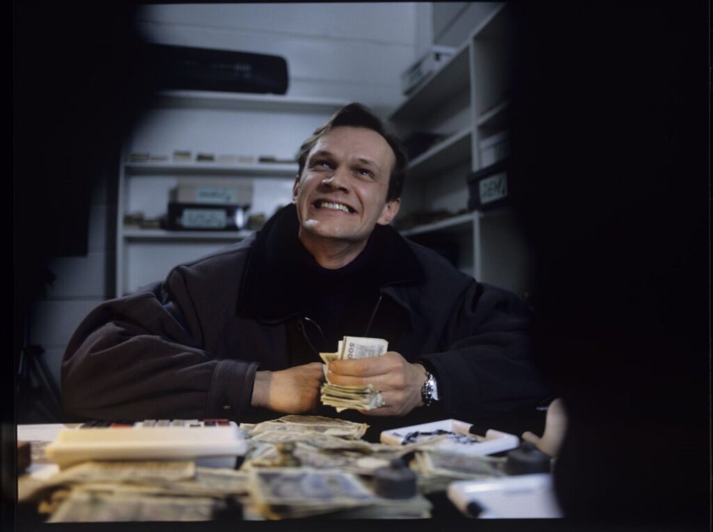 The owner of currency exchange bureau (Cezary Pazura) in the scne of counting the money