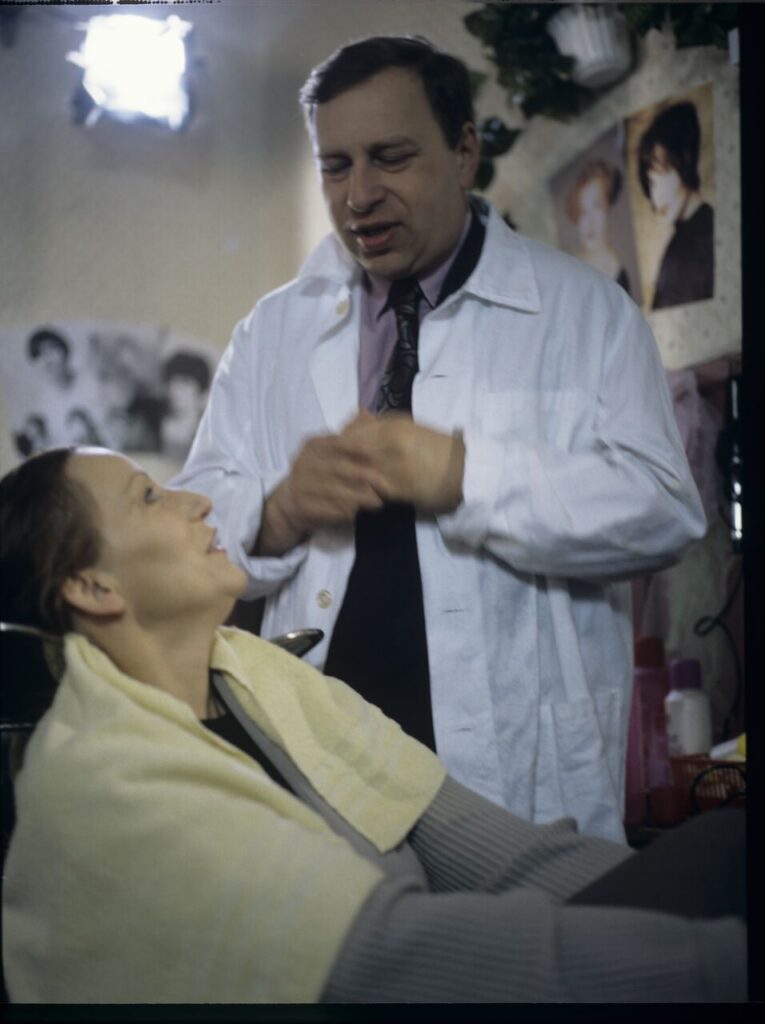 Jurek, Karol's brother (Jerzy Stuhr) with a client Mrs. Jadwiga (Teresa Budzisz-Krzyżanowska) in his hairdressing salon