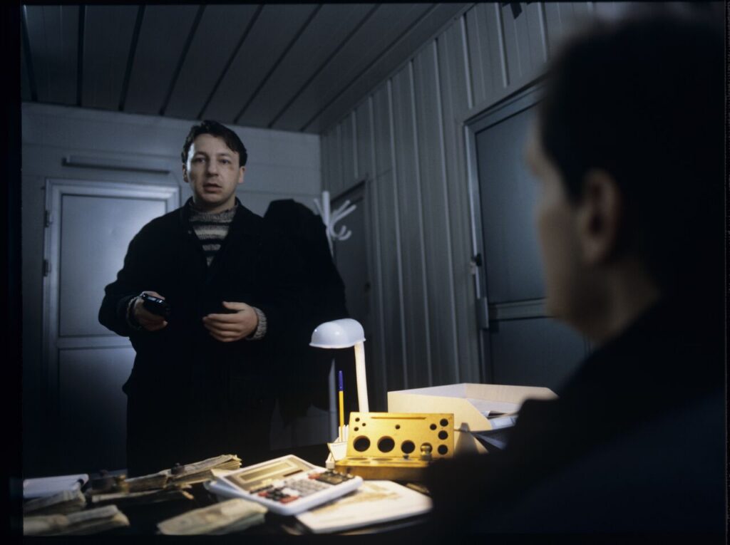 Karol (Zbigniew Zamachowski) arrives at the currency exchange office and asks the owner (Cezary Pazura) for a job.