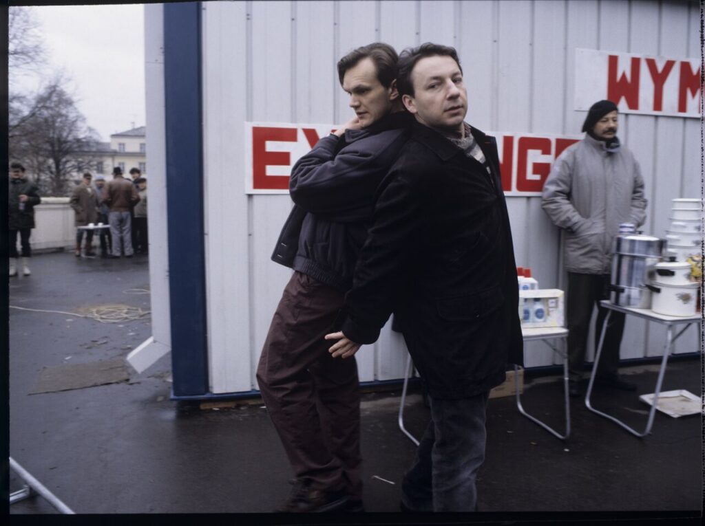 Karol (Zbigniew Zamachowski) while working as a bodyguard for the owner of a currency exchange office (Cezary Pazura).