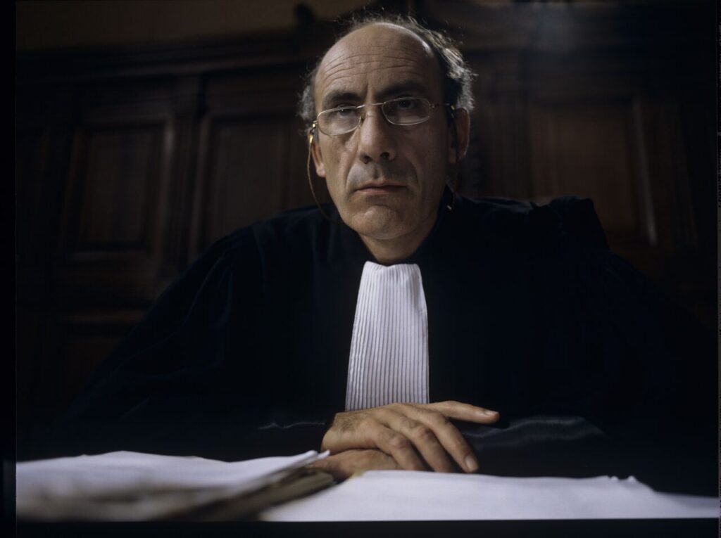 The judge (Philippe Morier Genoud) during Charles and Dominique's divorce case.