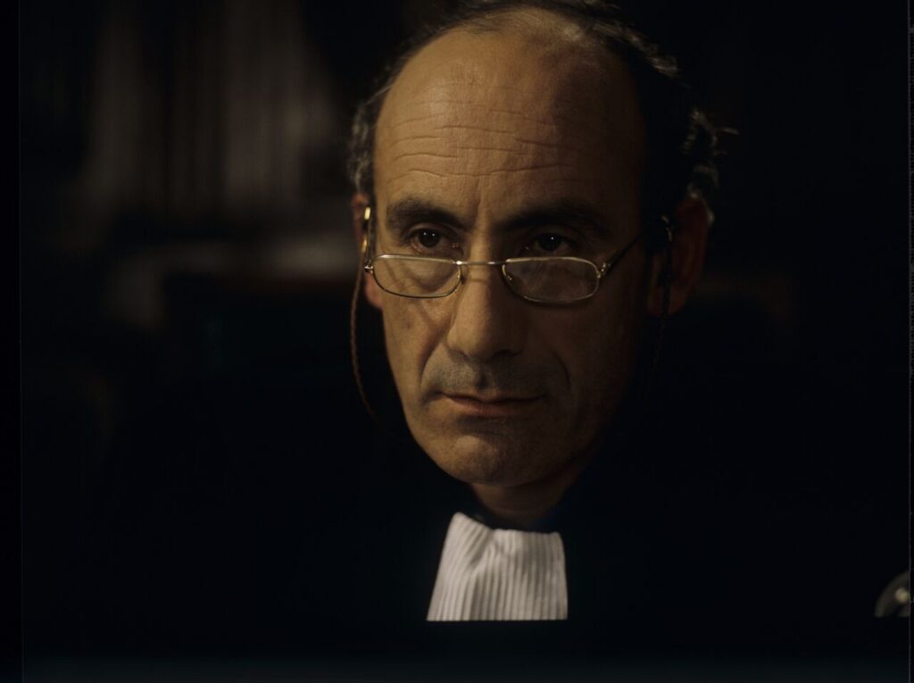 The judge (Philippe Morier Genoud) during Charles and Dominique's divorce case.
