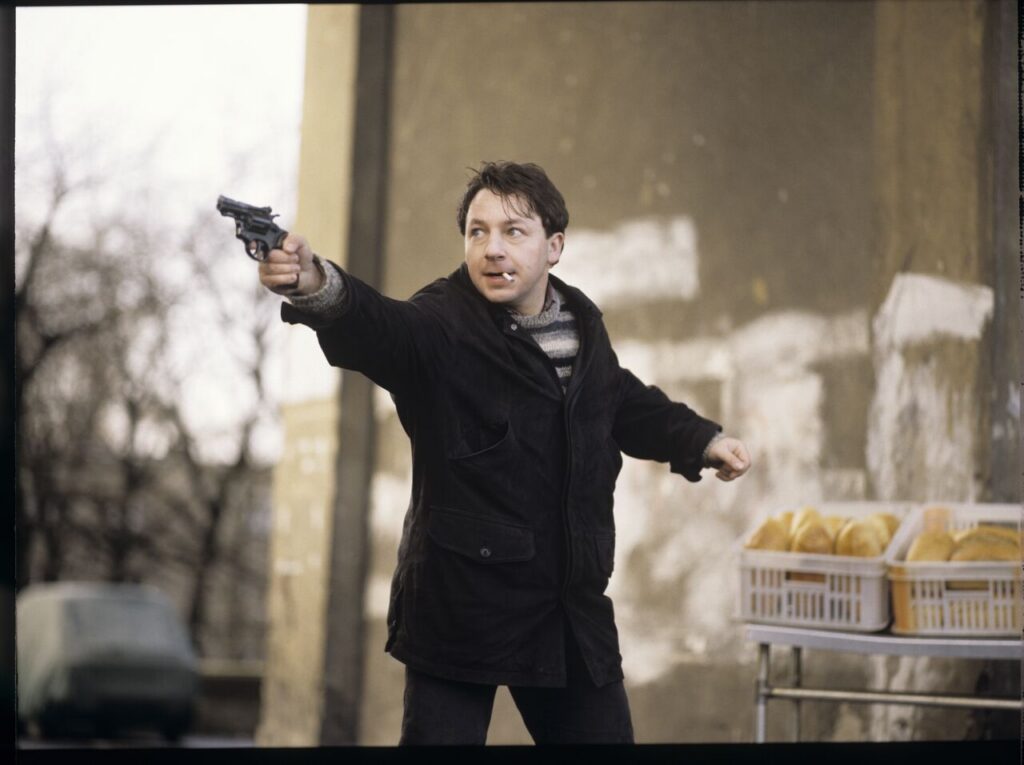 Karol (Zbigniew Zamachowski) and the "tall man" (Piotr Machalica) in front of the currency exchange office.