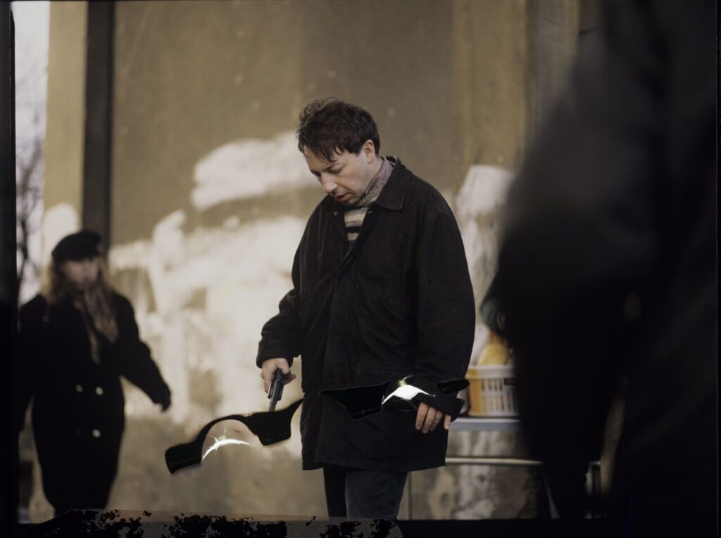 Karol (Zbigniew Zamachowski) and the "tall man" (Piotr Machalica) in front of the currency exchange office.