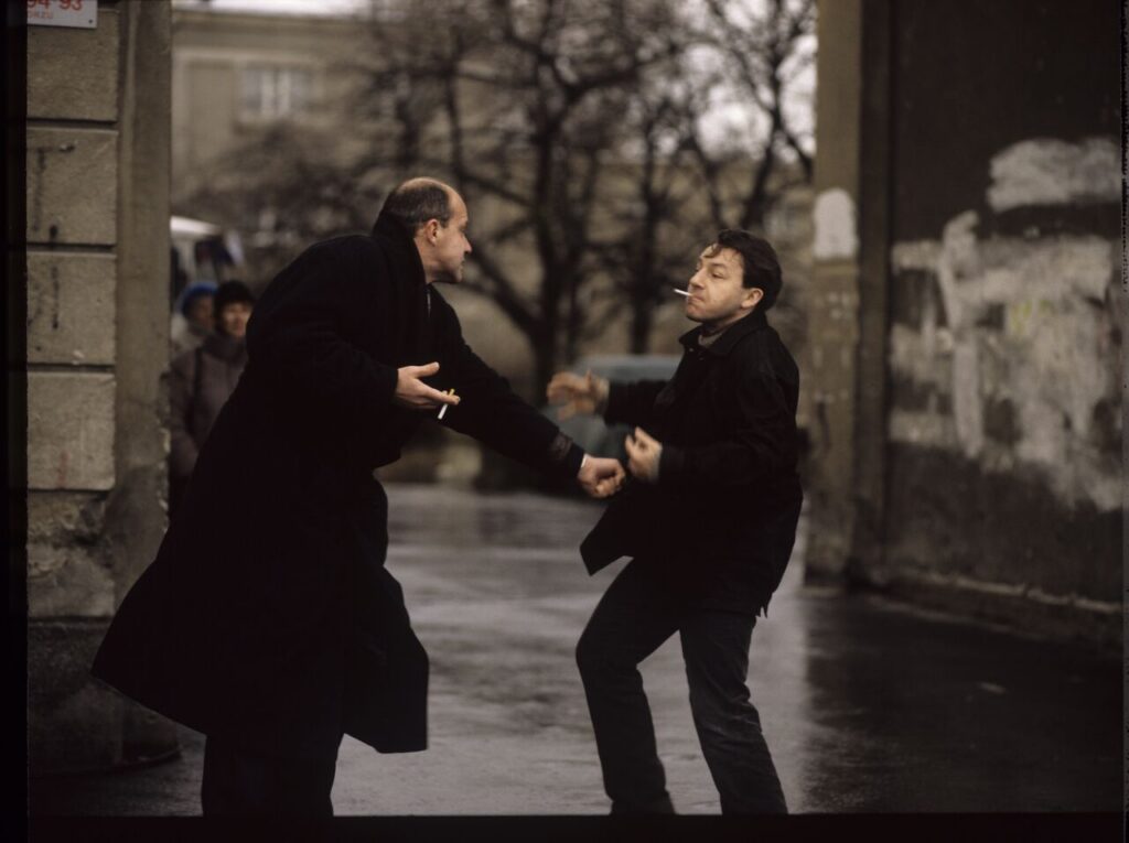 Karol (Zbigniew Zamachowski) and the "tall man" (Piotr Machalica) in front of the currency exchange office.