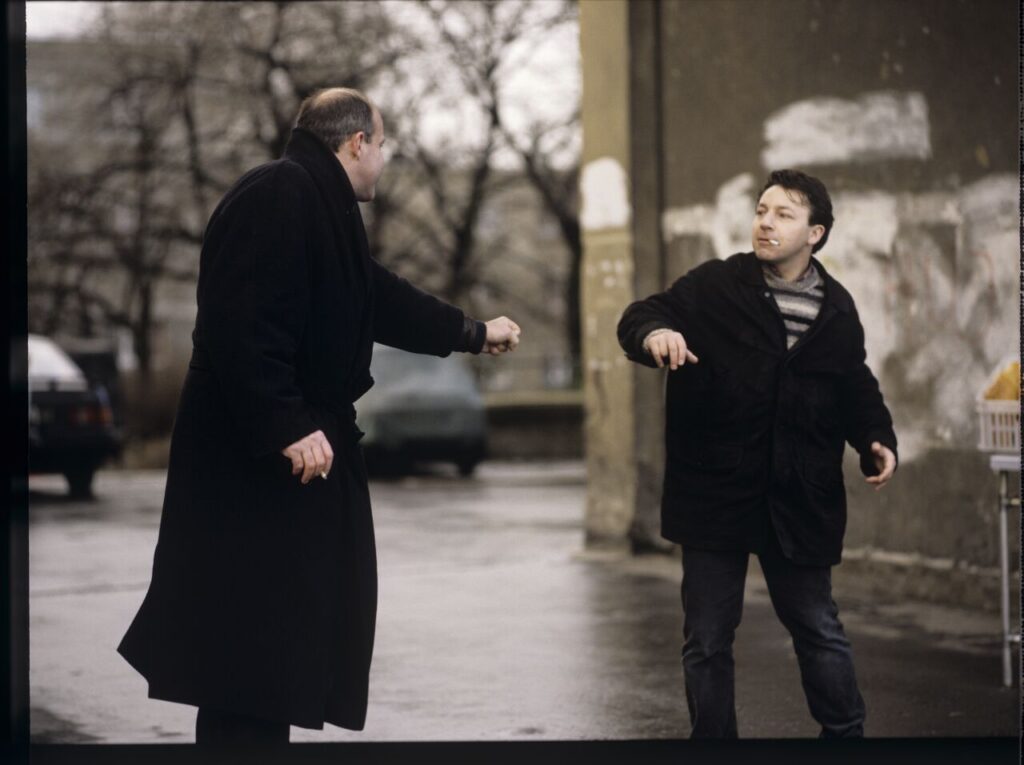 Karol (Zbigniew Zamachowski) and the "tall man" (Piotr Machalica) in front of the currency exchange office.