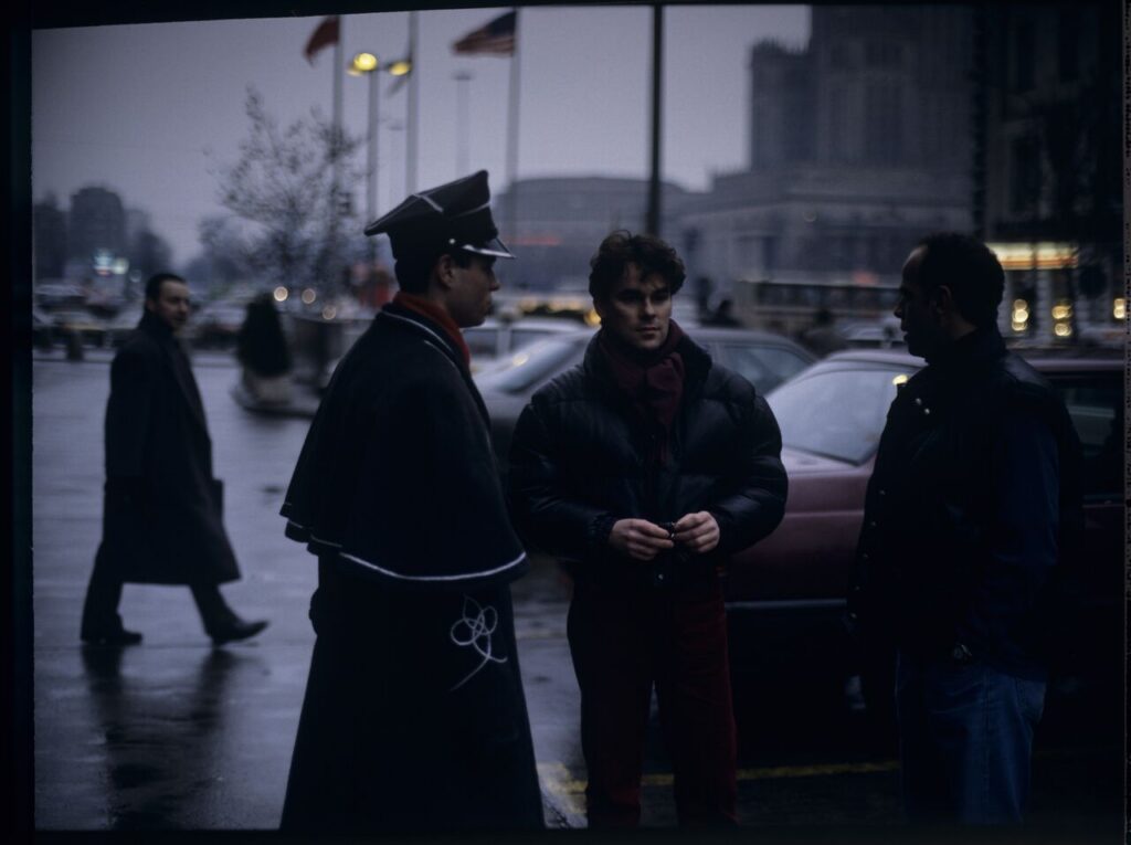 Passersby on a Warsaw street where Karol's car is parked.