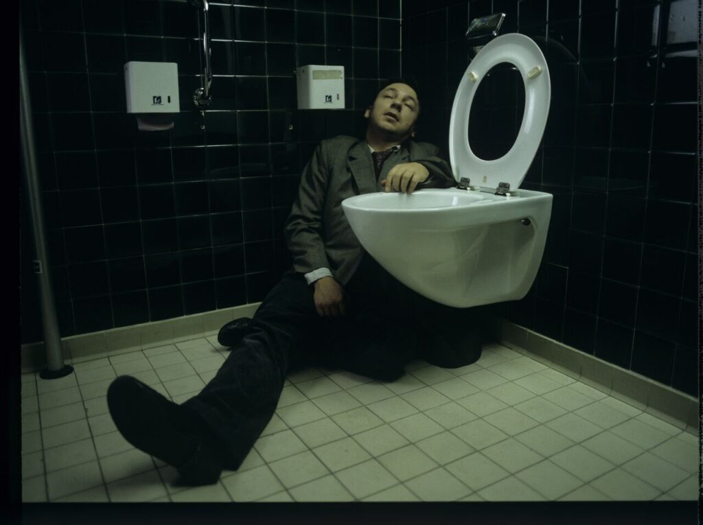 Karol (Zamachowski) in the toilet of the court building after an attack of torsion caused by emotions related to the divorce.