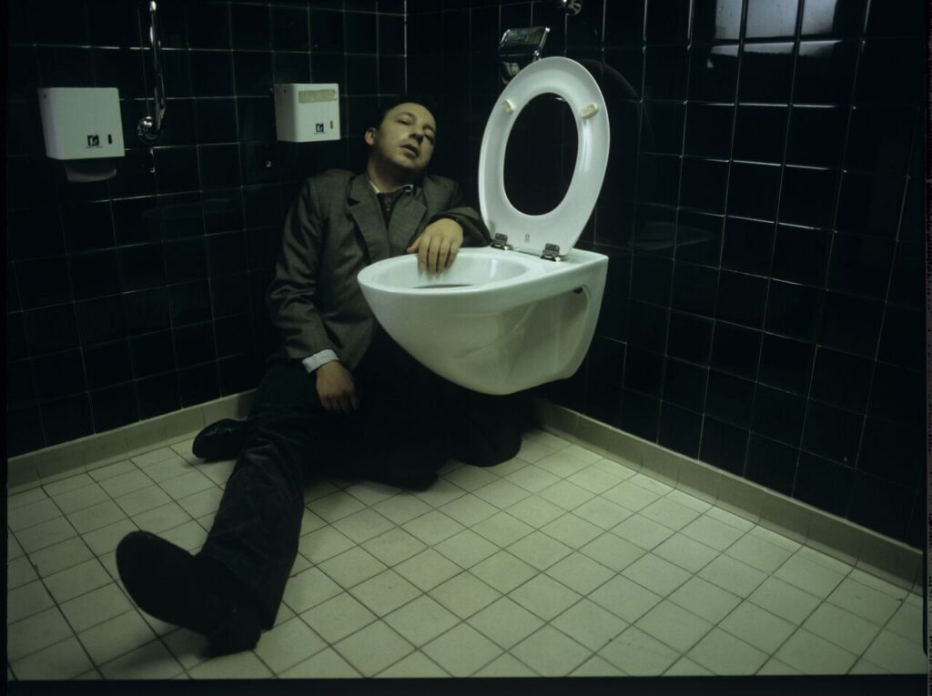 Karol (Zamachowski) in the toilet of the court building after an attack of torsion caused by emotions related to the divorce.