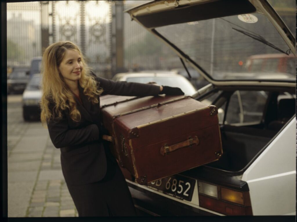 Dominique (Julie Delpy) takes a suitcase with Karol's things out of the car after the divorce hearing.