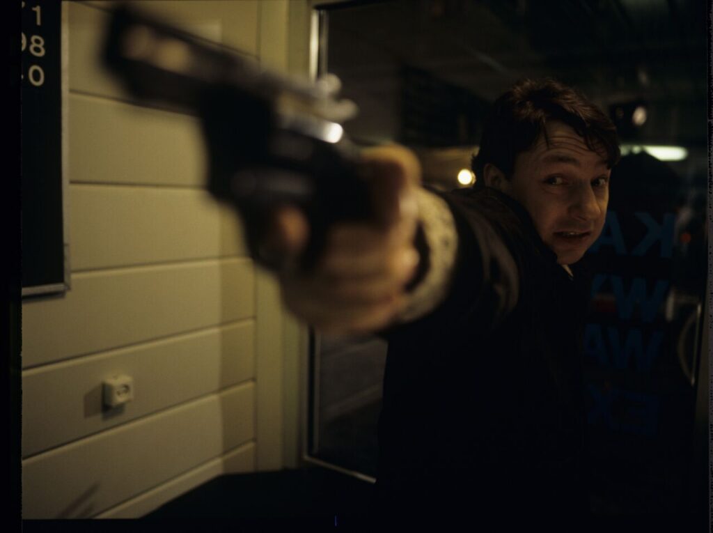 Karol (Zbigniew Zamachowski) working as a security guard at a currency exchange office.