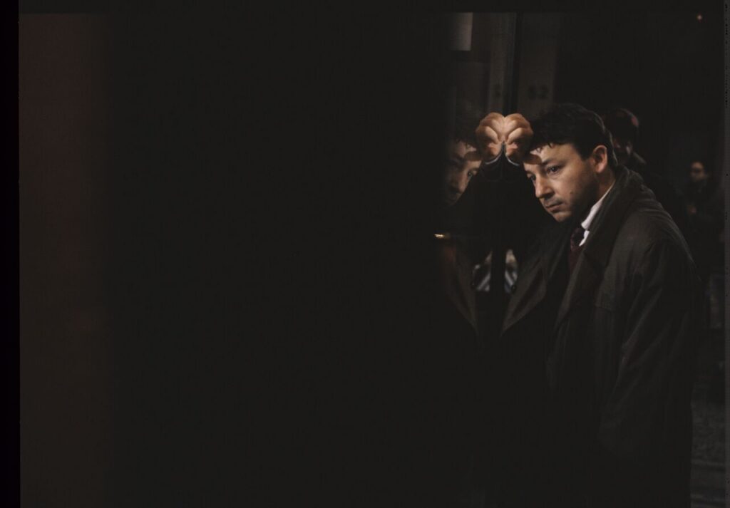 Zbigniew Zamachowski as Karol on the set in front of an antique shop.