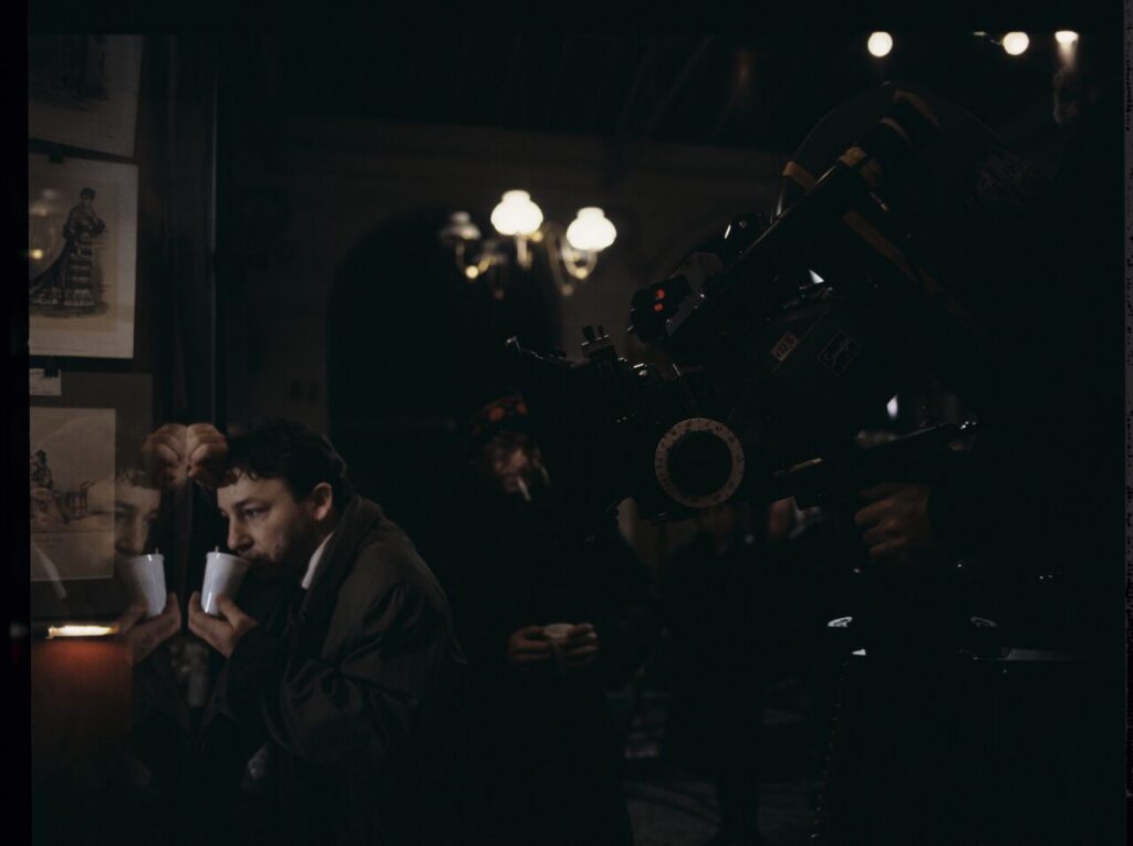 Zbigniew Zamachowski as Karol on the set in front of an antique shop.