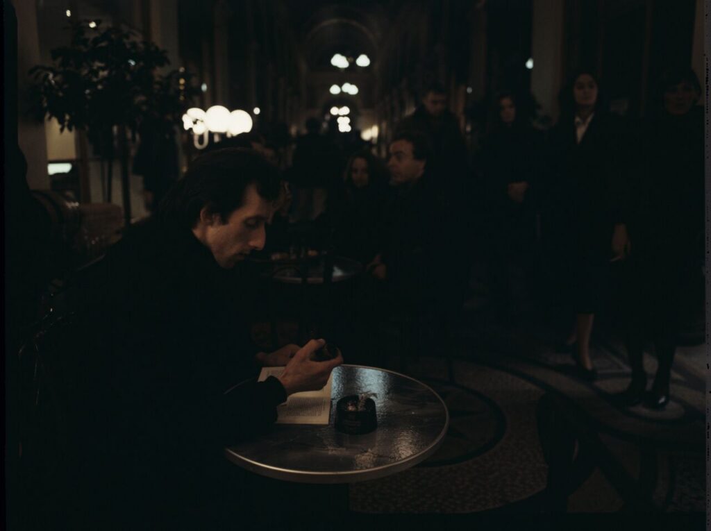 Parisian promenade, where, among elegant shops, there was an antique shop with an alabaster bust of a woman on display.