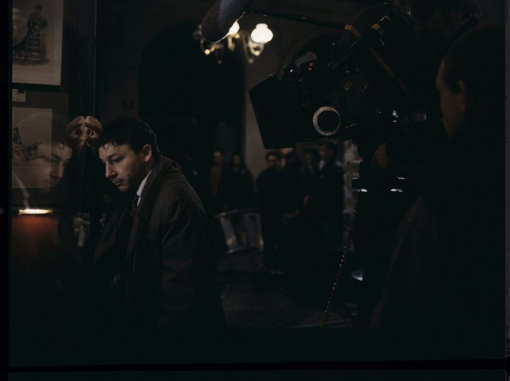 Zbigniew Zamachowski as Karol on the set in front of an antique shop.