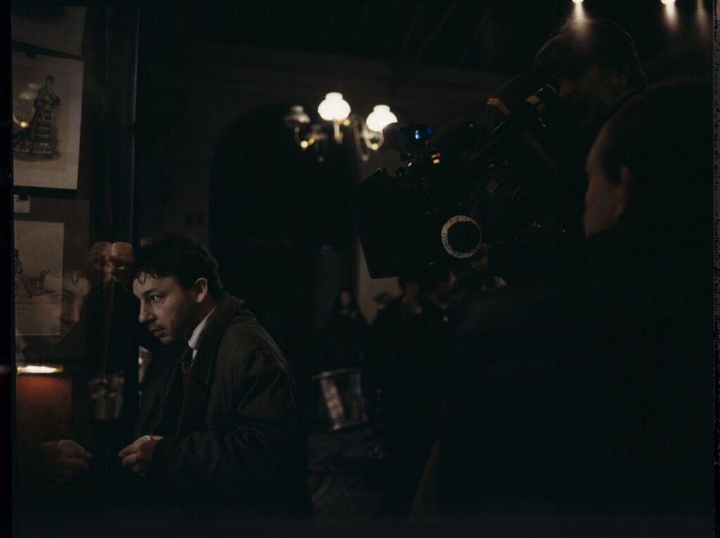 Zbigniew Zamachowski as Karol on the set in front of an antique shop.