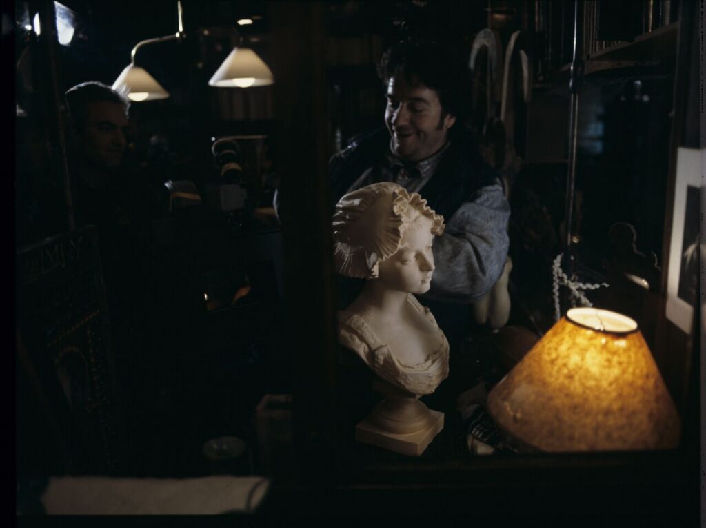Parisian promenade, where, among elegant shops, there was an antique shop with an alabaster bust of a woman on display.