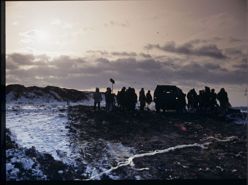 Krzysztof Kieślowski (director) surrounded by the crew on the set at a garbage dump.