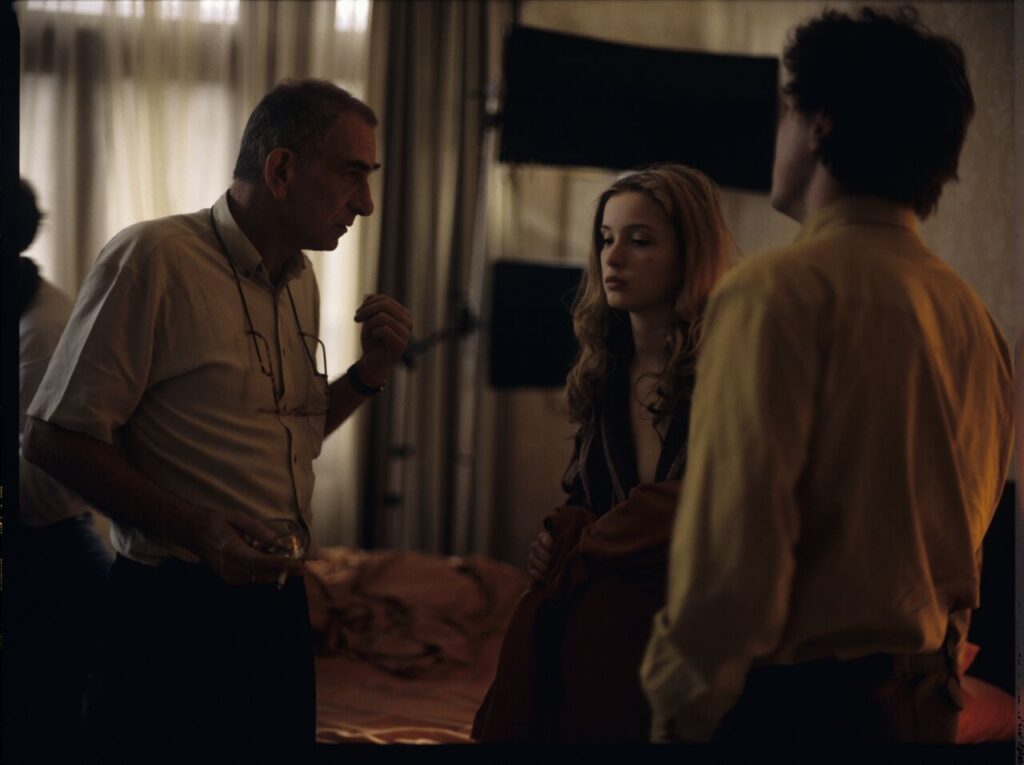 Krzysztof Kieślowski (director) gives instructions to Julie Delpy on the set in a hotel room.