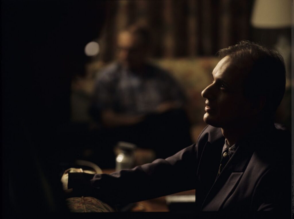 Cezary Harasimowicz as the police inspector who arrived at the hotel room to arrest Dominique.