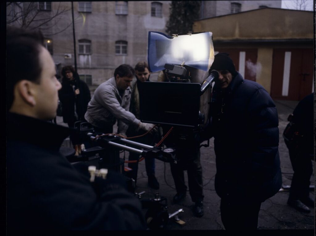 Filming a scene near the walls of the prison building where Karol's wife, Dominique, is serving a sentence.