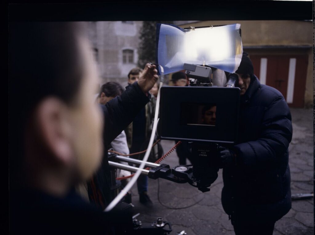 Filming a scene near the walls of the prison building where Karol's wife, Dominique, is serving a sentence.