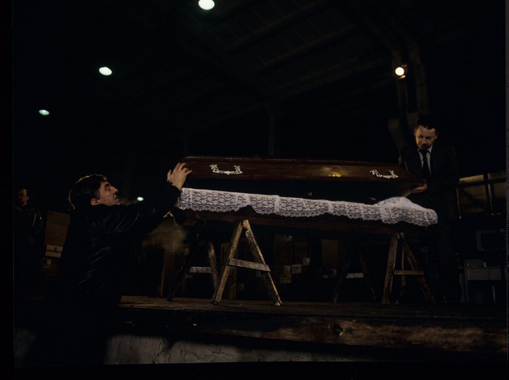 Karol (Zbigniew Zamachowski) and Mr. Bronek (Jerzy Trela) stand over the coffin of a "bought" corpse.