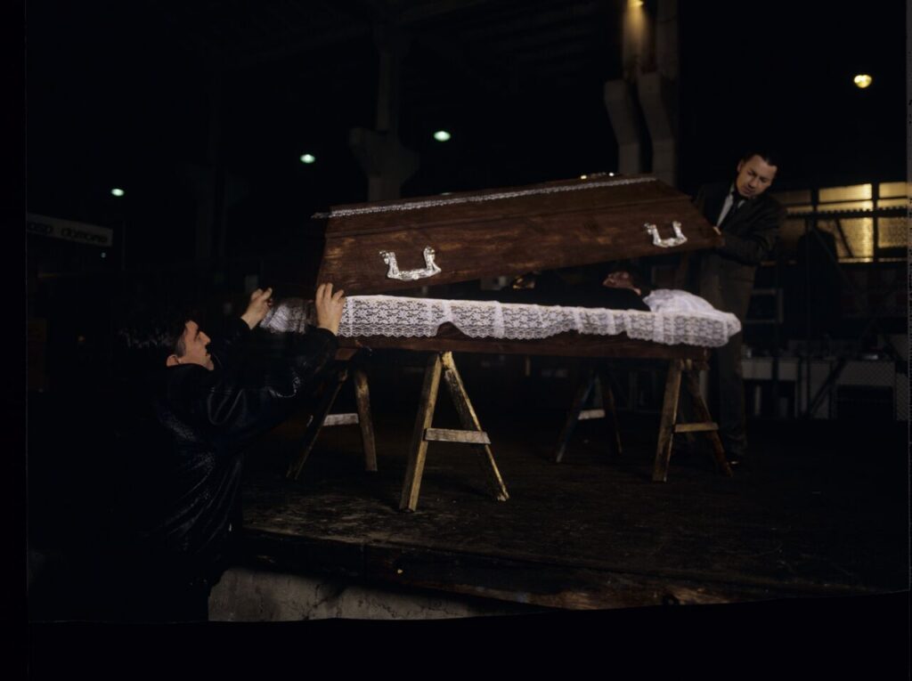 Karol (Zbigniew Zamachowski) and Mr. Bronek (Jerzy Trela) stand over the coffin of a "bought" corpse.
