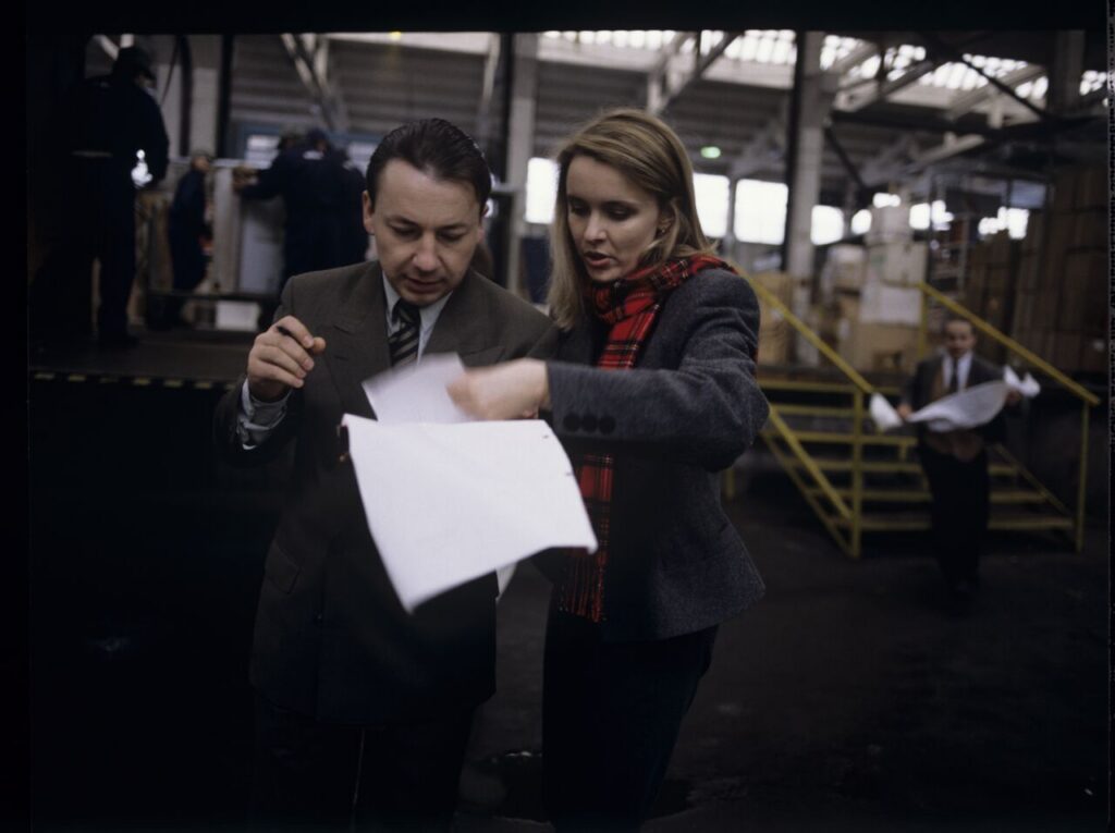 Karol (Zbigniew Zamachowski) taking to one of the workers in his new company.