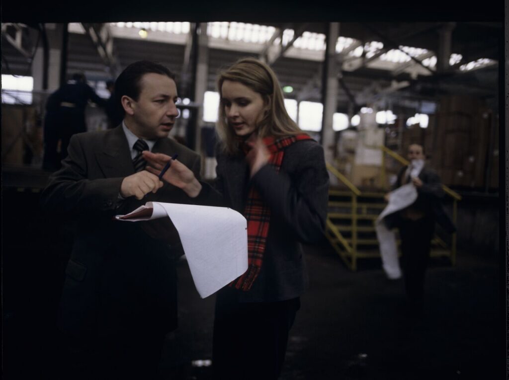 Karol (Zbigniew Zamachowski) taking to one of the workers in his new company.