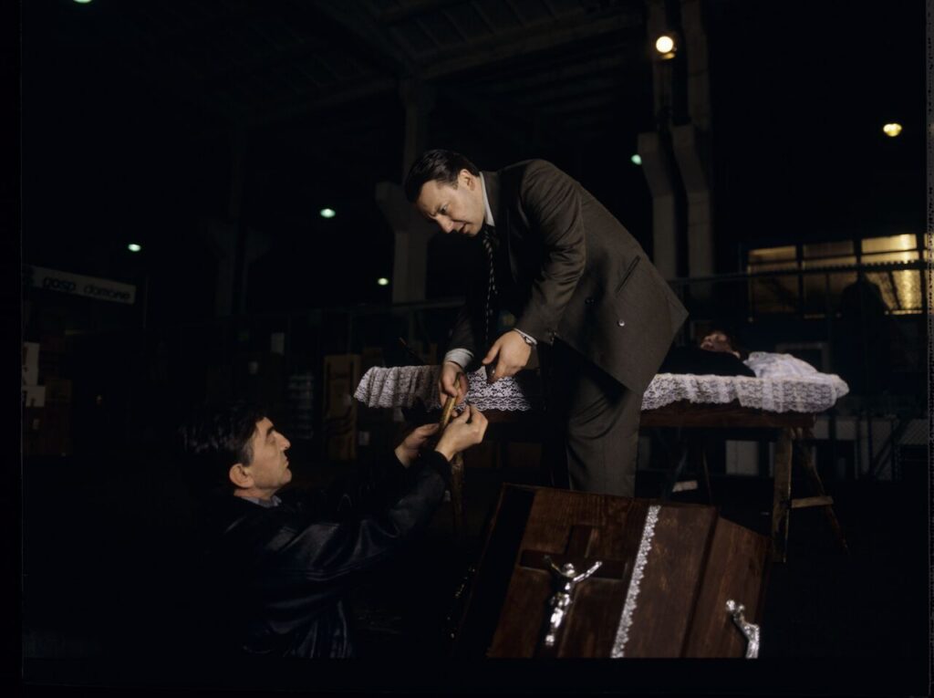Karol (Zbigniew Zamachowski) and Mr. Bronek (Jerzy Trela) stand over the coffin of a "bought" deceased.
