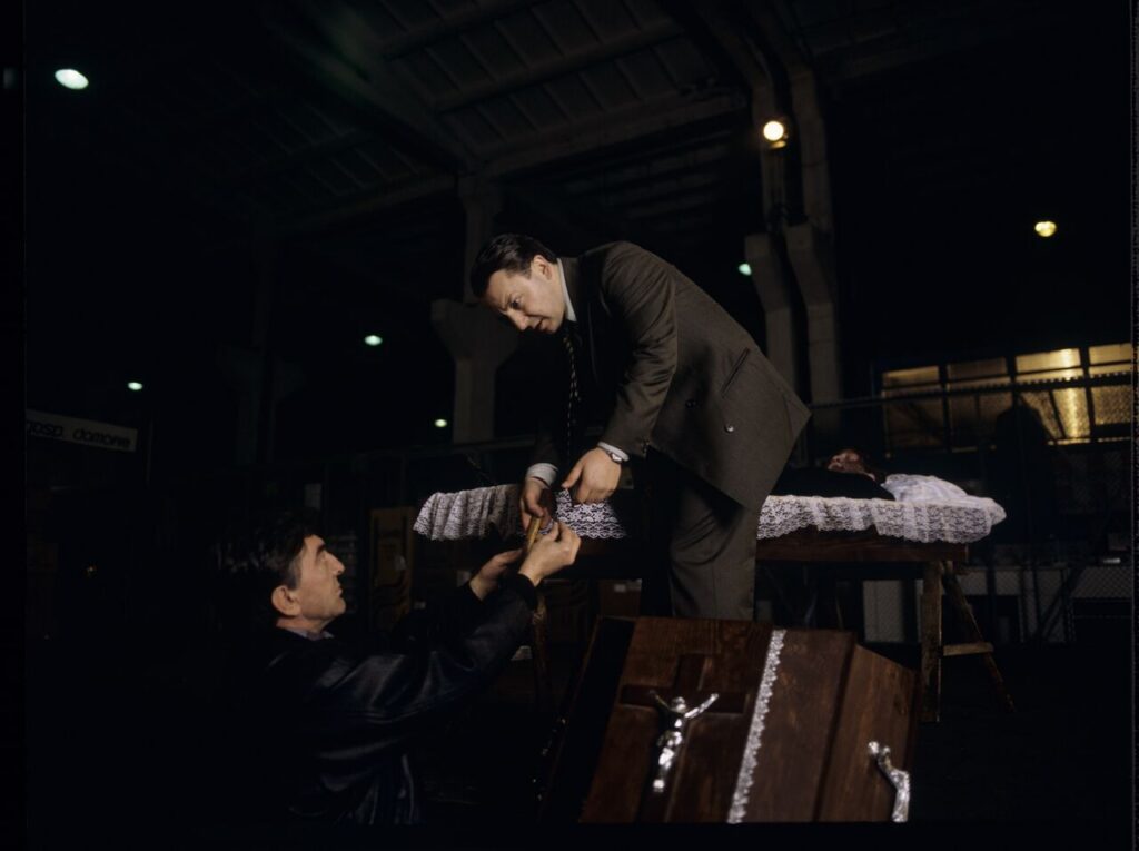 Karol (Zbigniew Zamachowski) and Mr. Bronek (Jerzy Trela) stand over the coffin of a "bought" deceased.
