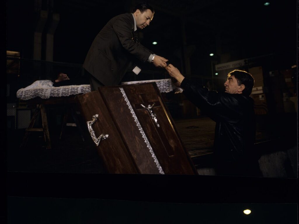 Karol (Zbigniew Zamachowski) and Mr. Bronek (Jerzy Trela) stand over the coffin of a "bought" deceased.