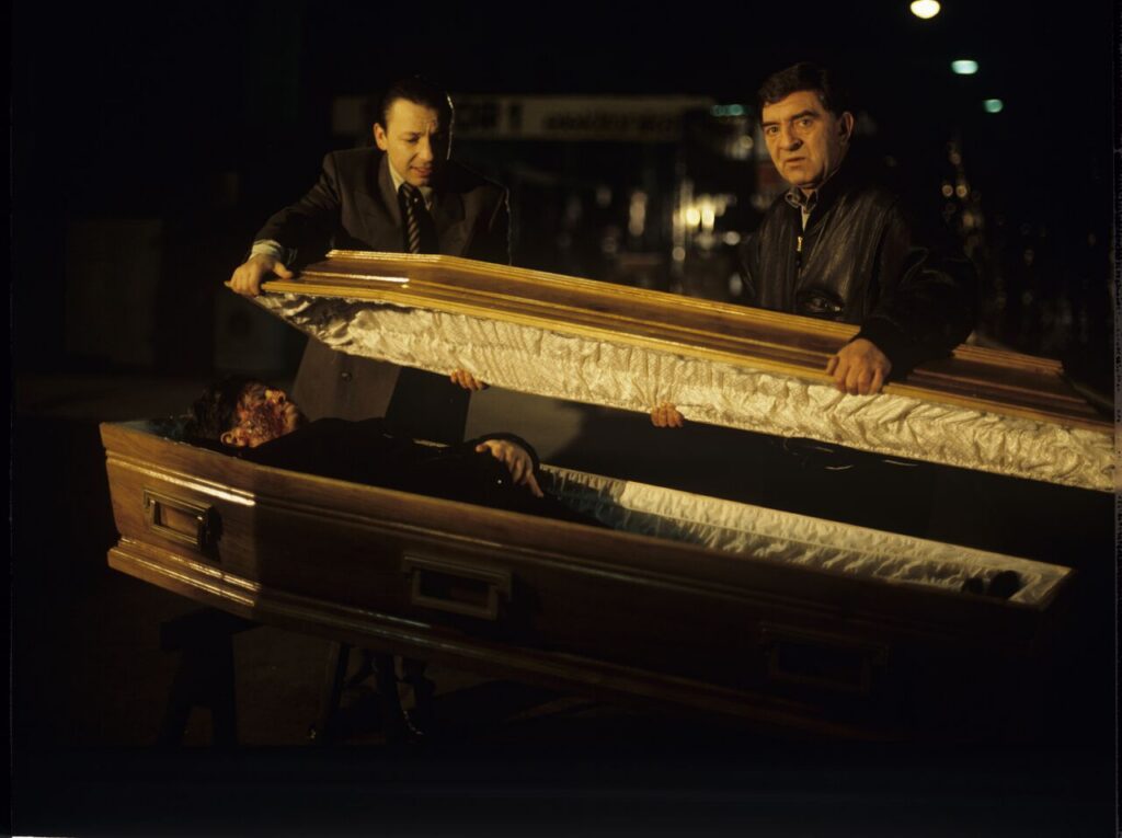 Karol (Zbigniew Zamachowski) and Mr. Bronek (Jerzy Trela) stand over the coffin of a "bought" deceased.
