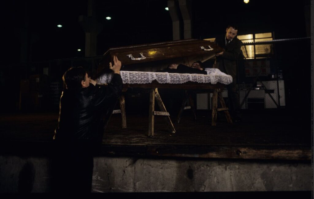 Karol (Zbigniew Zamachowski) and Mr. Bronek (Jerzy Trela) stand over the coffin of a "bought" deceased.