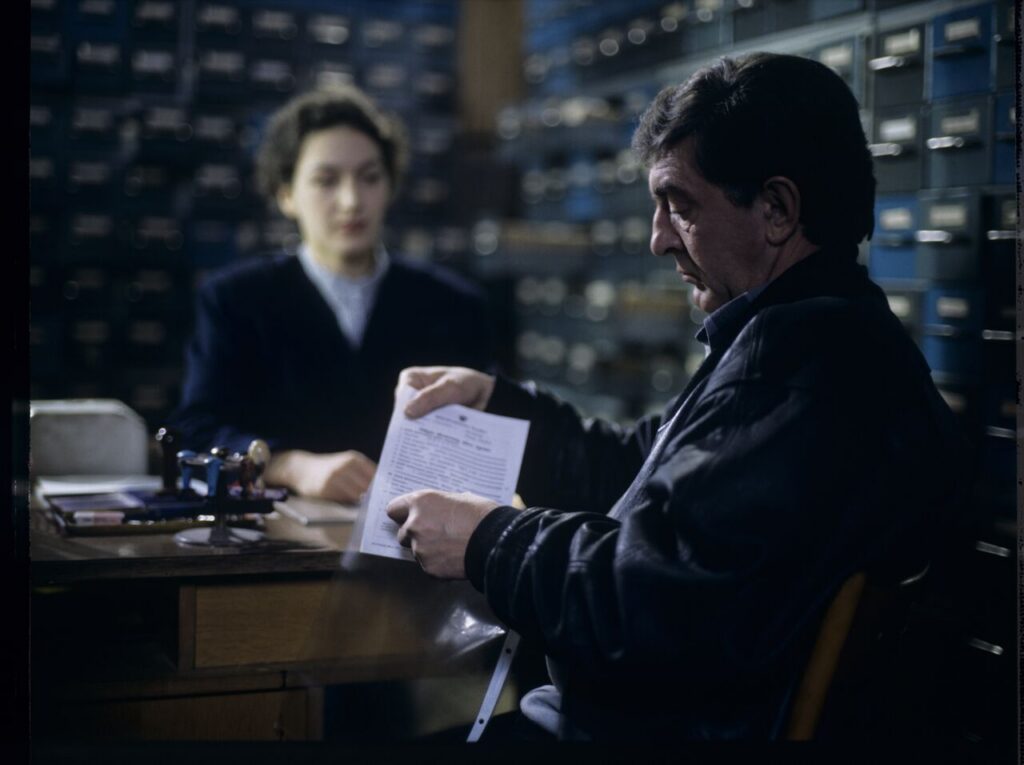 Mr. Bronek, Karol's driver is giving Karol (Zbigniew Zamachowski) documents confirming his death.