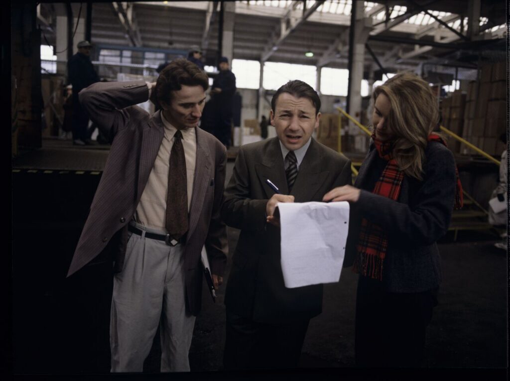 Karol (Z. Zamachowski), an efficient businessman, signs documents presented to him by employees of his new company.