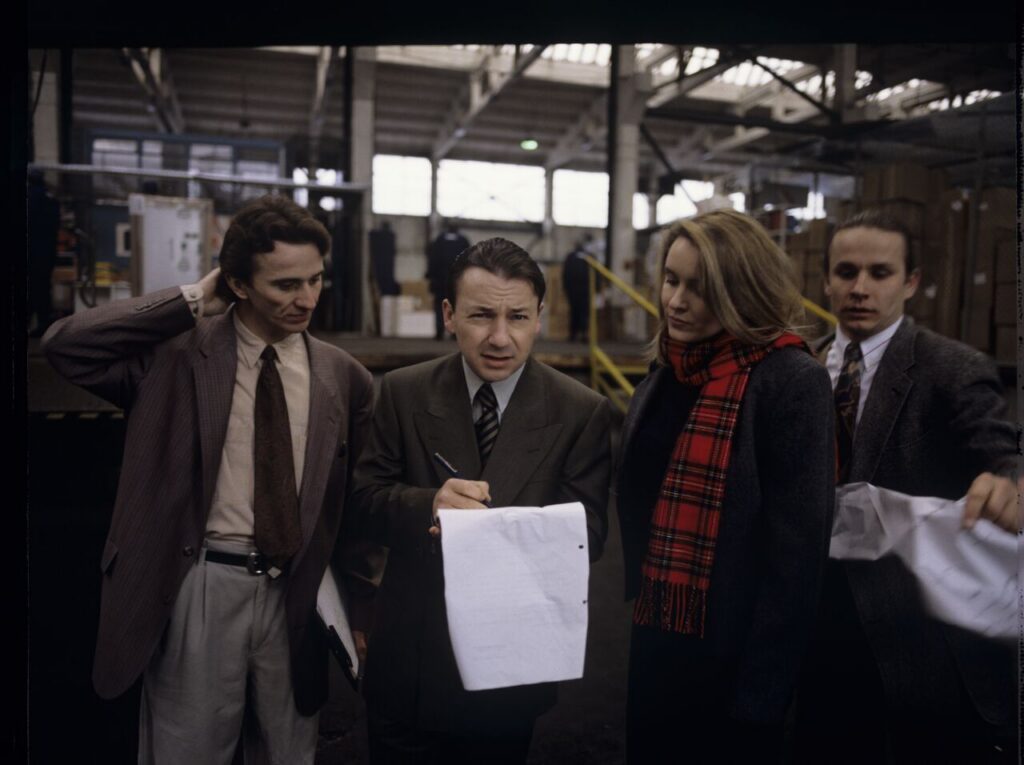 Karol (Z. Zamachowski), an efficient businessman, signs documents presented to him by employees of his new company.