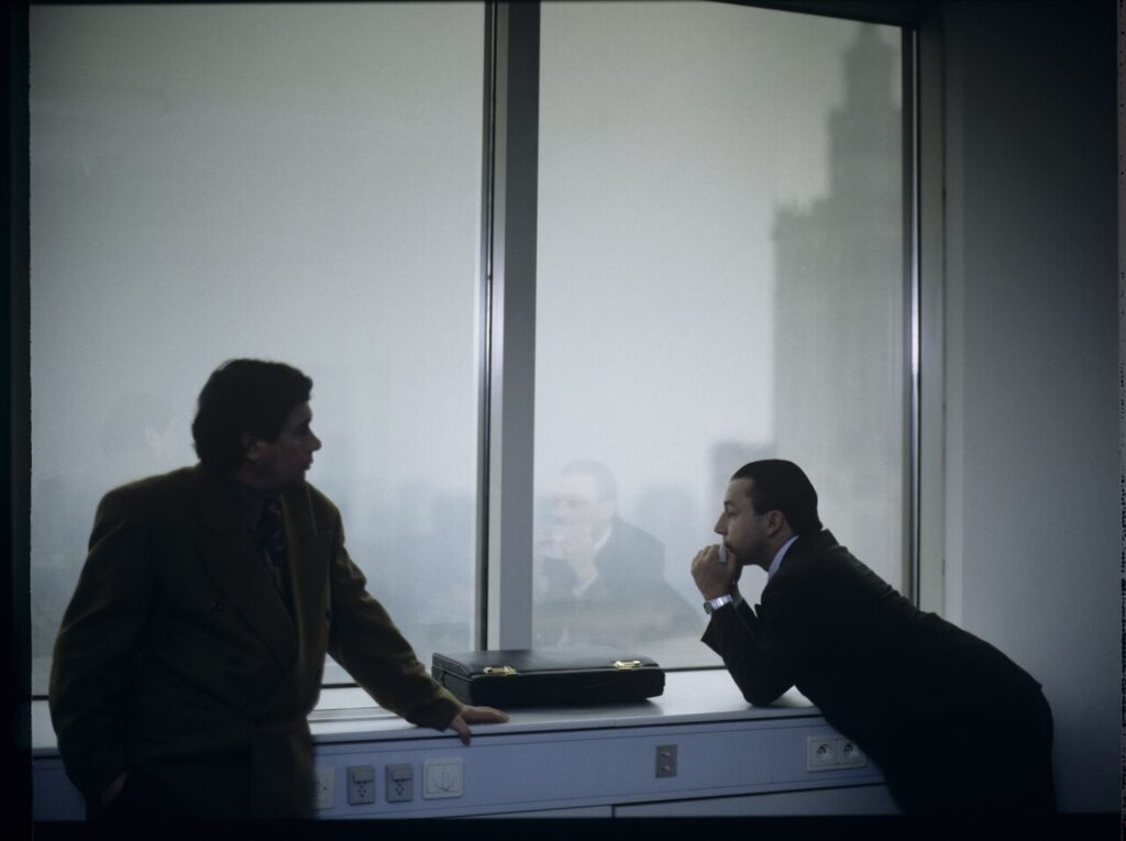 Karol (Zbigniew Zamachowski) plays a melody on a comb in his new office at the Marriott Hotel.