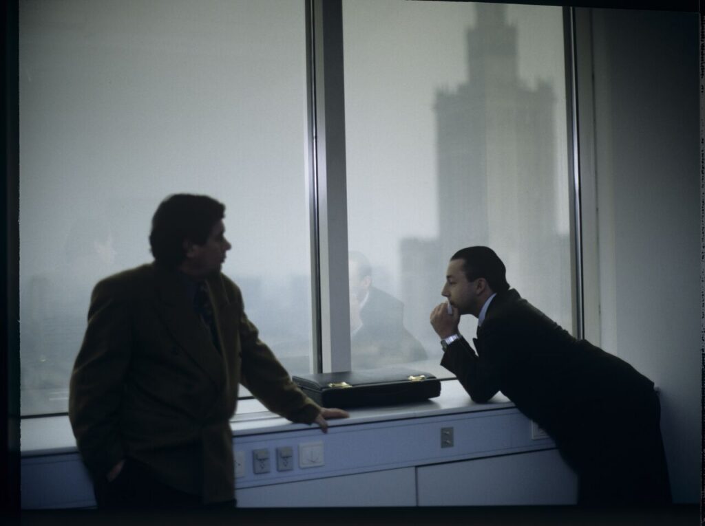 Karol (Zbigniew Zamachowski) plays a melody on a comb in his new office at the Marriott Hotel.