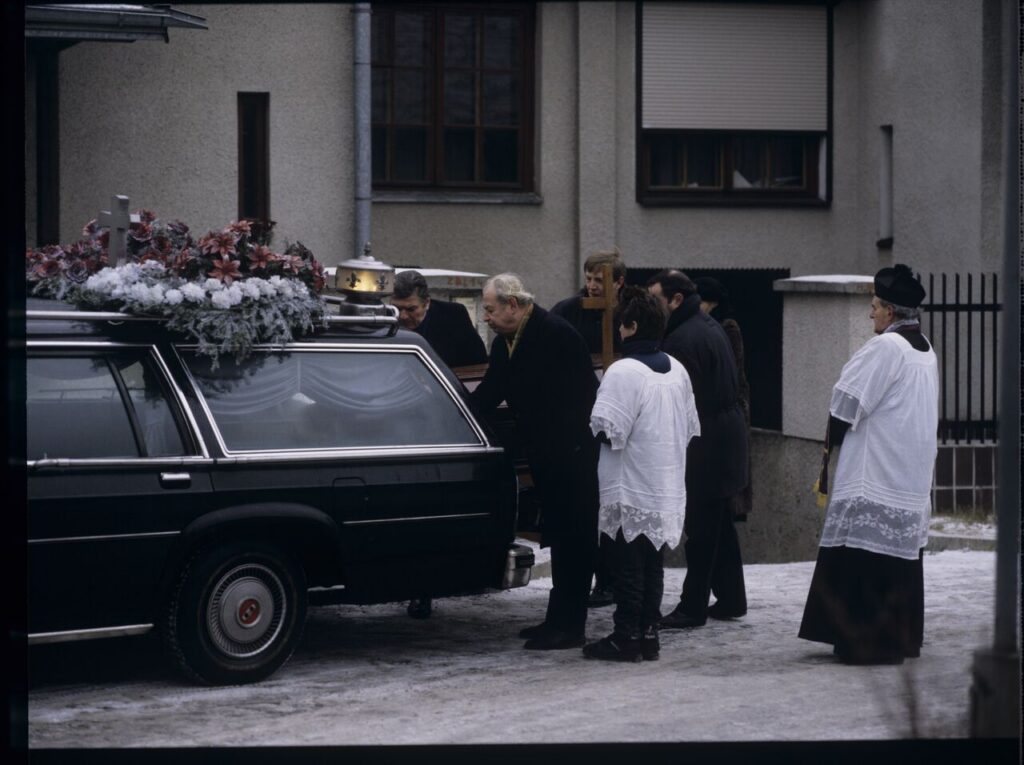 The funeral scene that Charles observes on the street near Nicholas's house.