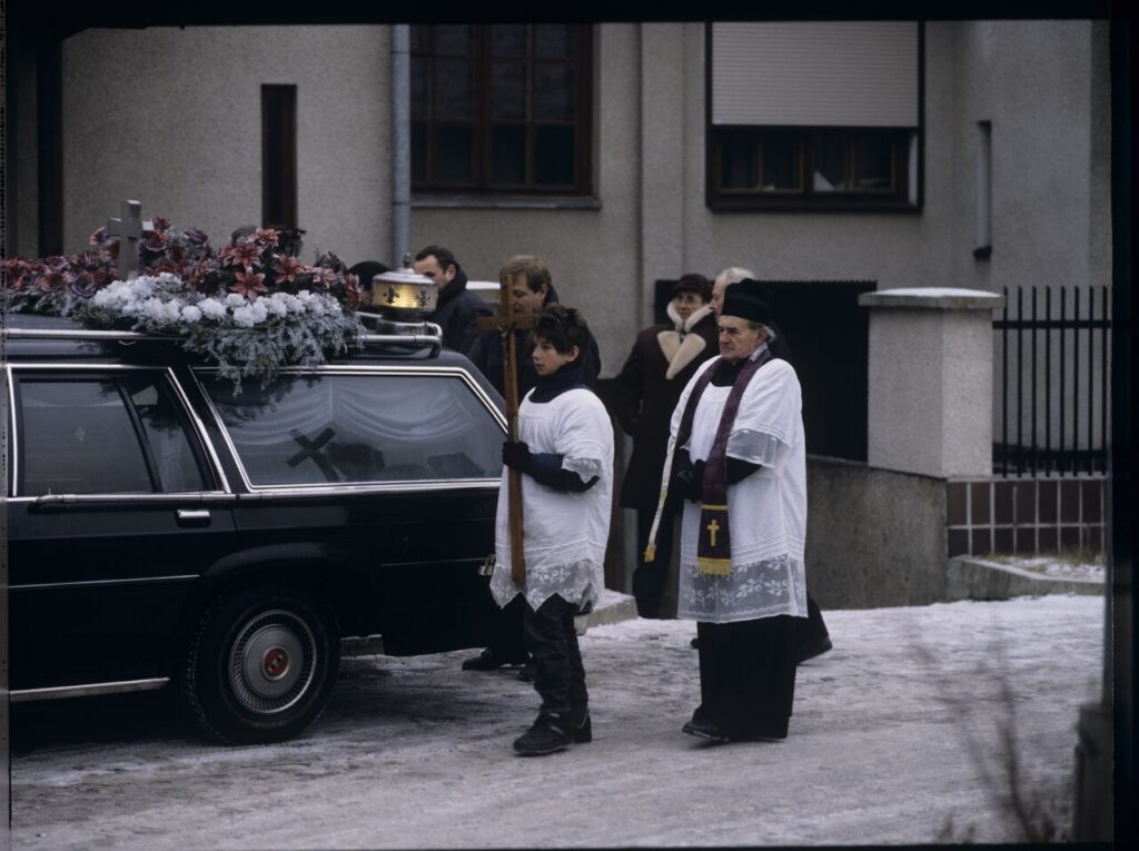 The funeral scene that Charles observes on the street near Nicholas's house.