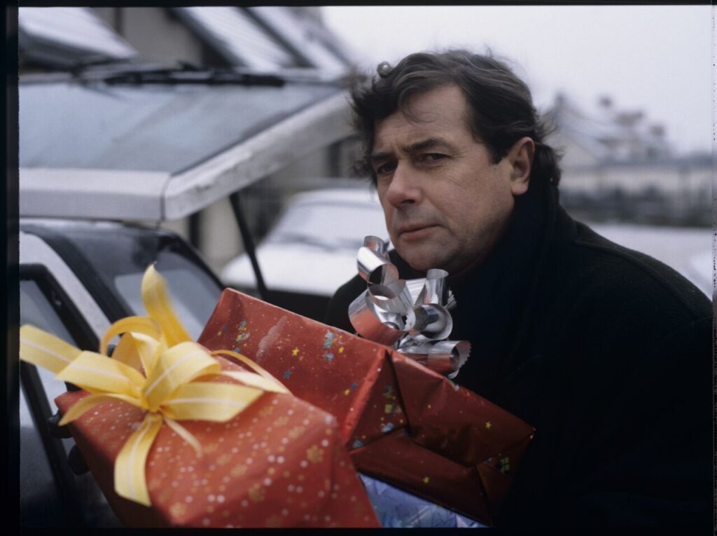 Mikołaj (Janusz Gajos) in front of his house with Christmas gifts for his family