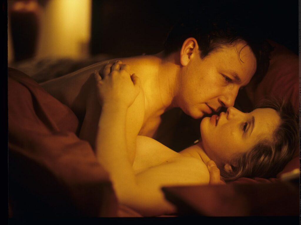 Dominique (Julie Delpy) and Karol (Zbigniew Zamachowski) in an intimate scene in a hotel room.