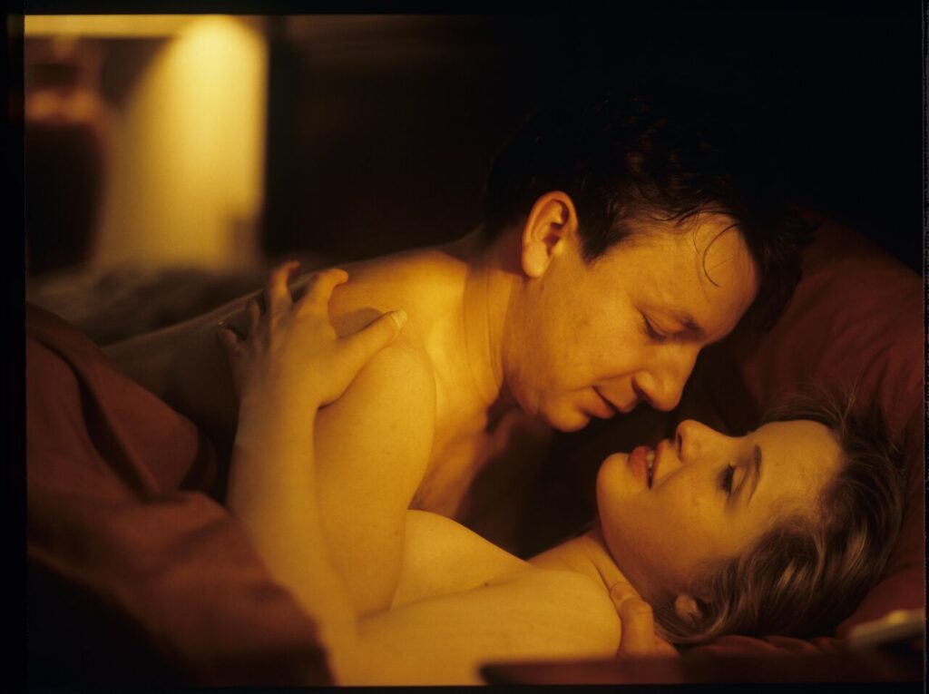 Dominique (Julie Delpy) and Karol (Zbigniew Zamachowski) in an intimate scene in a hotel room.